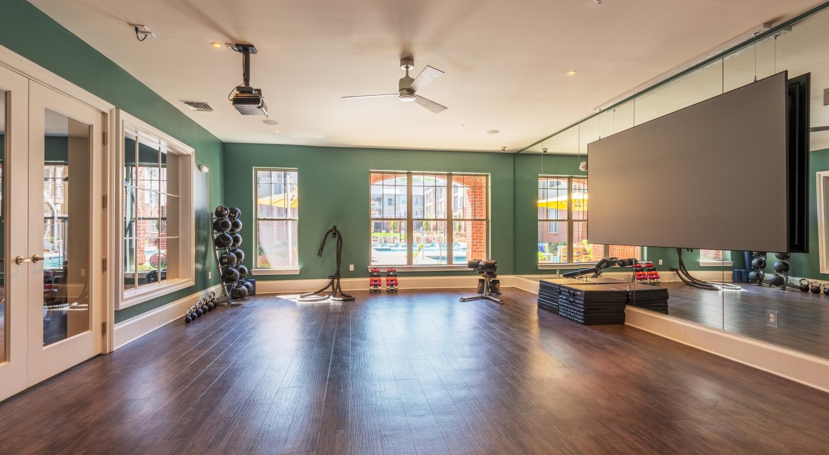 Cutting-edge amenities at your fingertips a room with a wood floor and a large window with a large screen