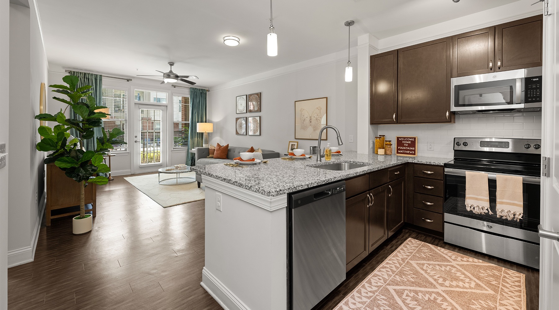 Kitchen with island and dark wood cabinets at Fountains Matthews apartments in Matthews, NC.